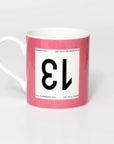 Pink mug with black 13 in the style of a Tour de France cyclist's race number.