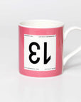 Pink mug with black 13 in the style of a Tour de France cyclist's race number.