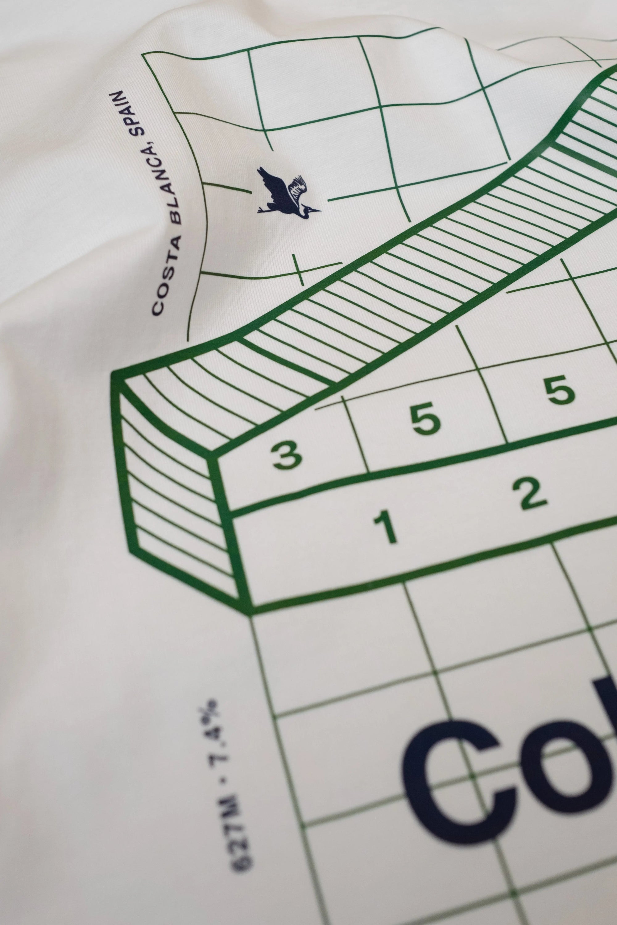 Close-up of white Climbs Profiles T-shirt with Spanish cycling climb Coll de Rates' graphic, by the Handmade Cyclist