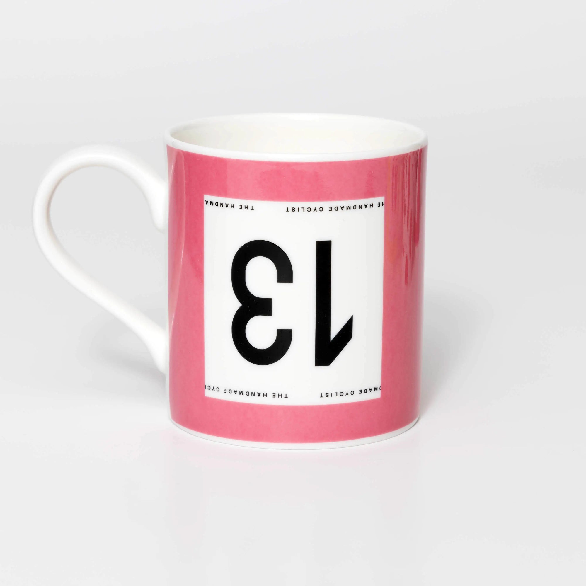 Pink mug with black 13 in the style of a Tour de France cyclist's race number.