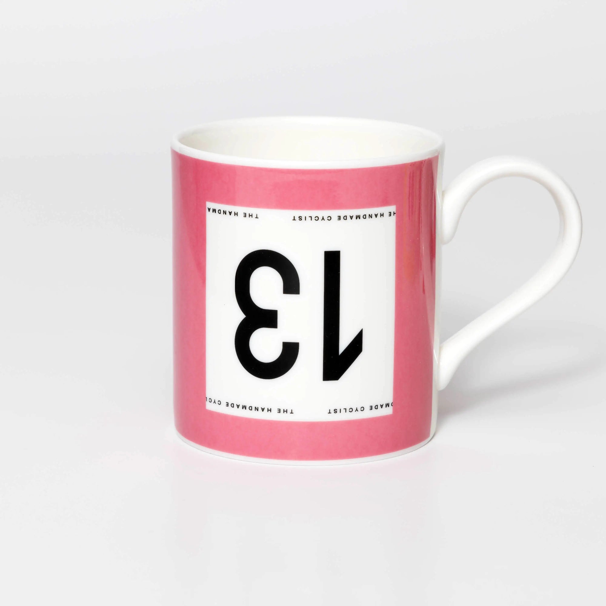 Pink mug with black 13 in the style of a Tour de France cyclist's race number.