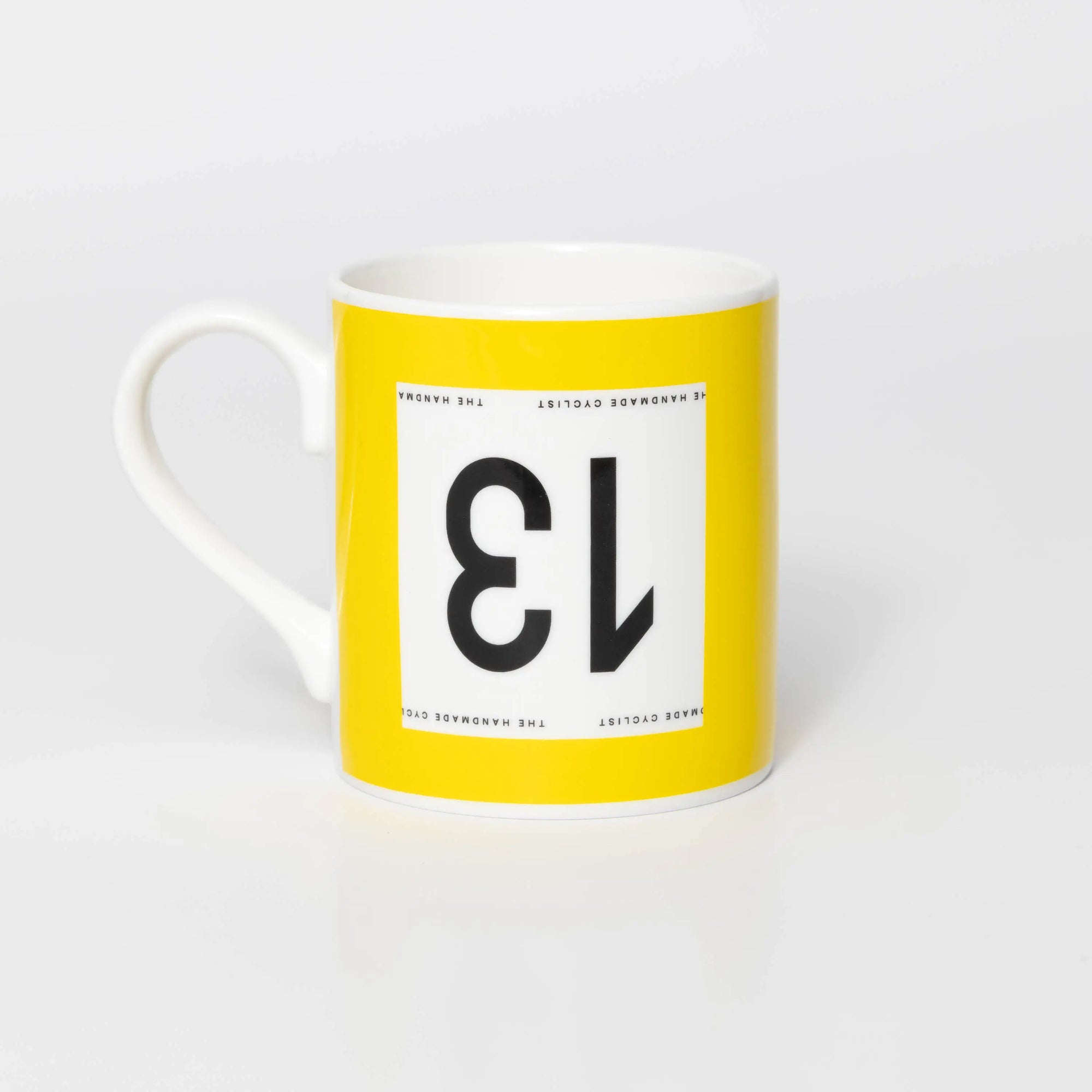 Yellow mug with black 13 in the style of a Tour de France cyclist's race number.