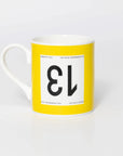 Yellow mug with black 13 in the style of a Tour de France cyclist's race number.