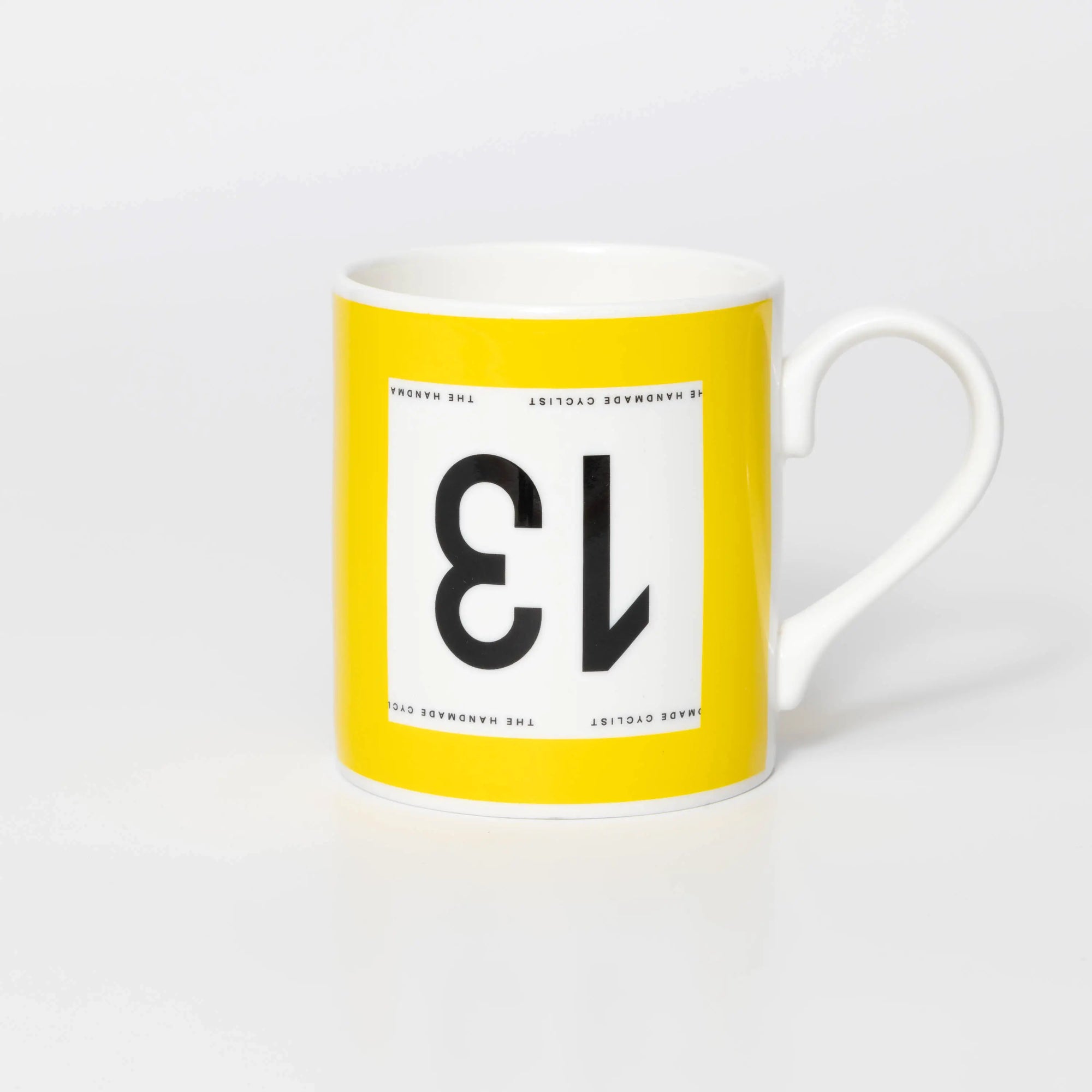 Yellow mug with black 13 in the style of a Tour de France cyclist's race number.