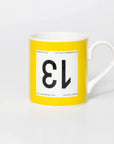 Yellow mug with black 13 in the style of a Tour de France cyclist's race number.