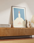 Wooden sideboard with a lamp, vase, and framed cycling art print of Le Mont Ventoux by Handmade Cyclist in a black frame.